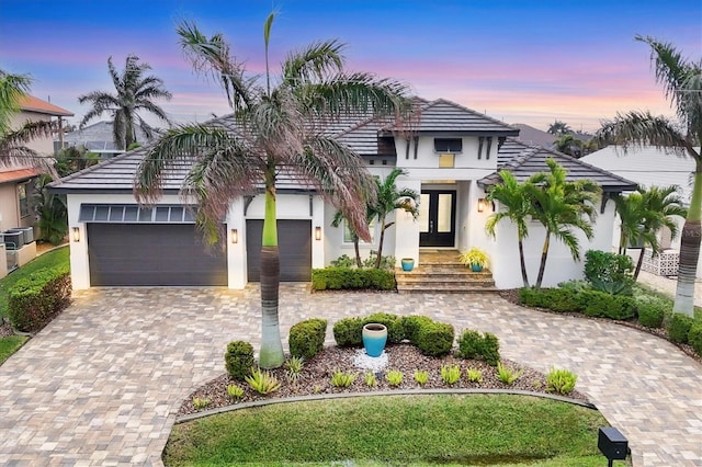 view of front of property with cooling unit and a garage