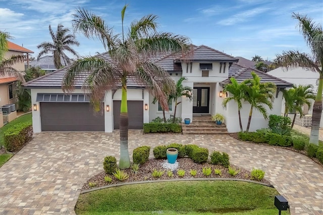 view of front of house with cooling unit and a garage