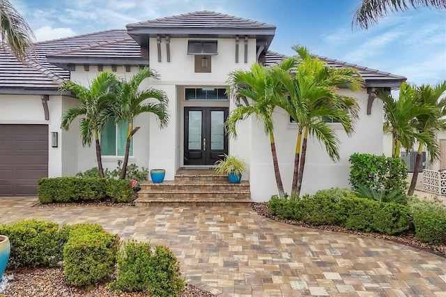 entrance to property featuring a garage and french doors