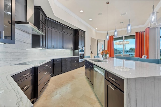 kitchen with sink, hanging light fixtures, a large island, and wall chimney exhaust hood