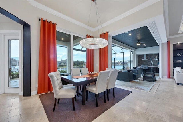 dining space featuring crown molding, a water view, and a healthy amount of sunlight