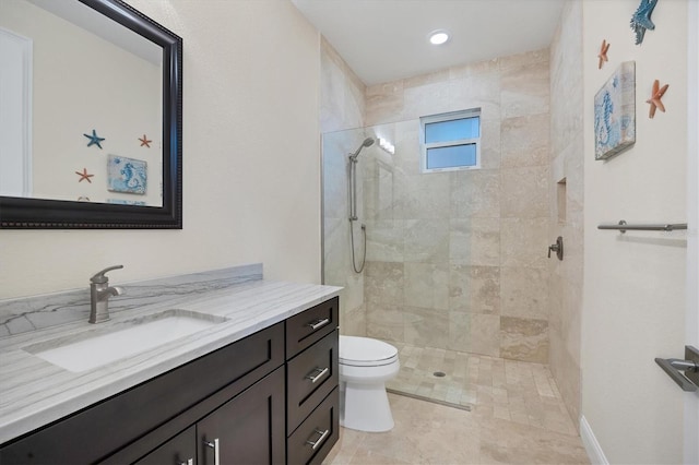 bathroom featuring vanity, toilet, and tiled shower