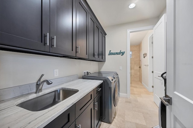 clothes washing area with sink, cabinets, and washing machine and clothes dryer