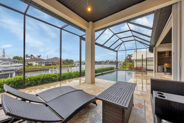 view of pool featuring a lanai, a water view, and a patio