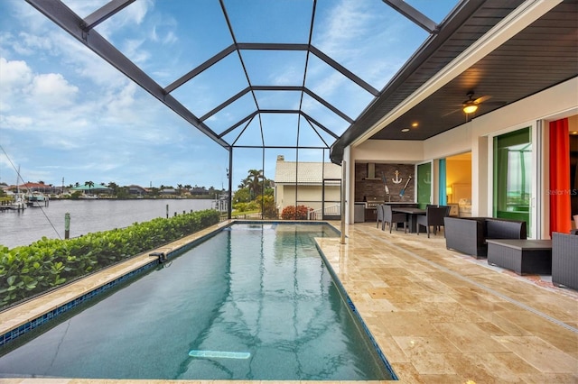 view of swimming pool featuring ceiling fan, a water view, exterior bar, a lanai, and a patio area