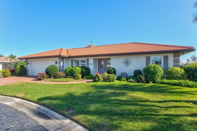 view of front of home with a garage and a front lawn