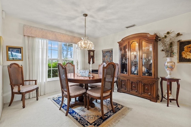 carpeted dining space featuring a notable chandelier