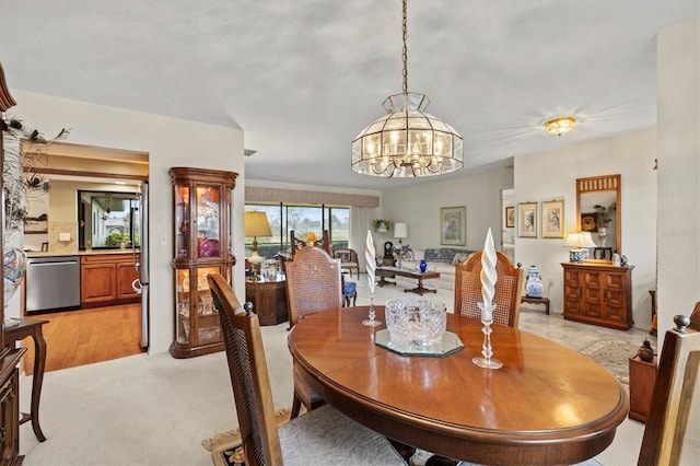 dining area with light colored carpet and a notable chandelier