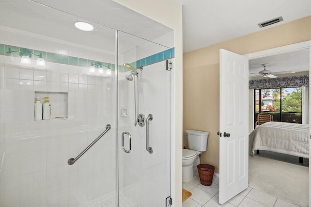 bathroom featuring tile patterned flooring, a shower with door, ceiling fan, and toilet