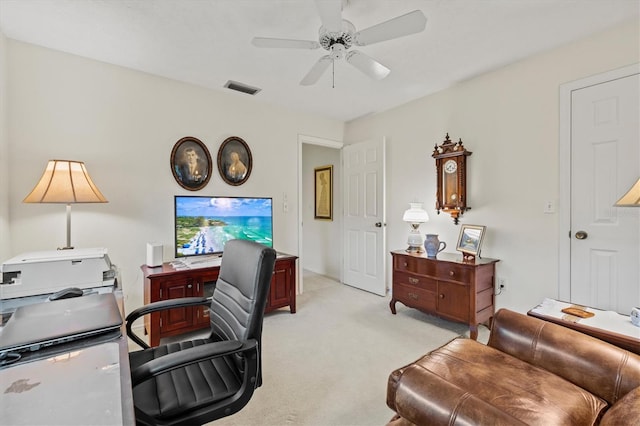 carpeted office space featuring ceiling fan