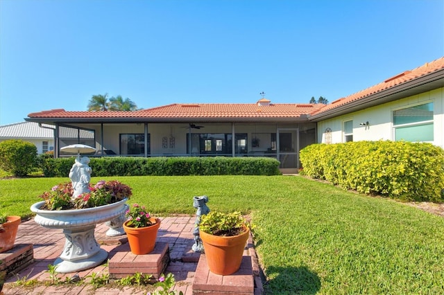 rear view of property with a lawn and a sunroom