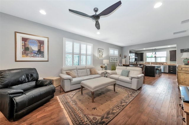 living room with ceiling fan and dark wood-type flooring