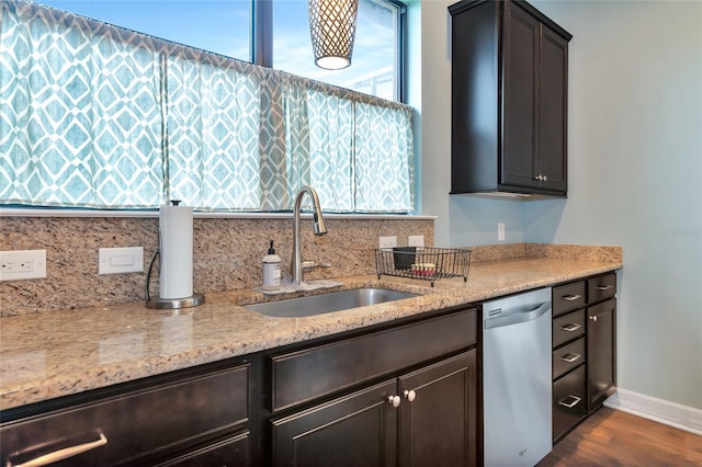 kitchen with sink, dishwasher, dark hardwood / wood-style floors, dark brown cabinets, and light stone countertops