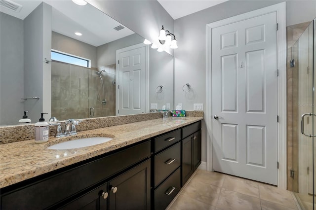 bathroom featuring tile patterned floors, an enclosed shower, and vanity