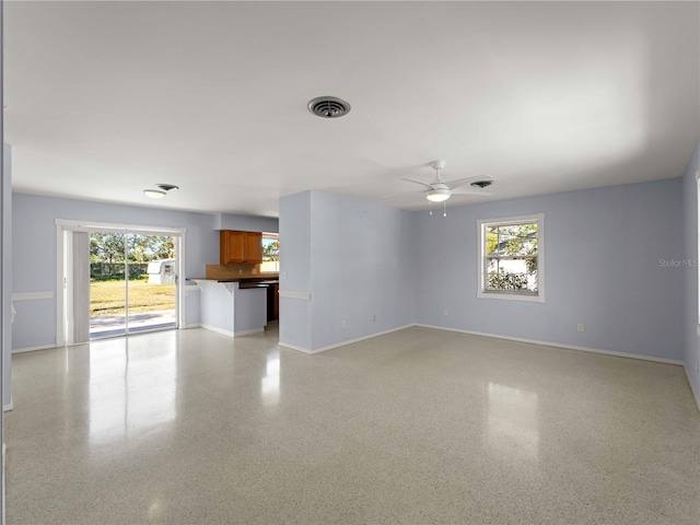 unfurnished living room with ceiling fan and a healthy amount of sunlight