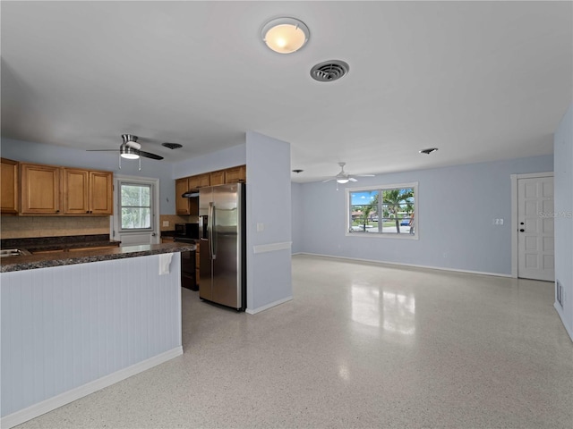 kitchen with ceiling fan, tasteful backsplash, and stainless steel fridge