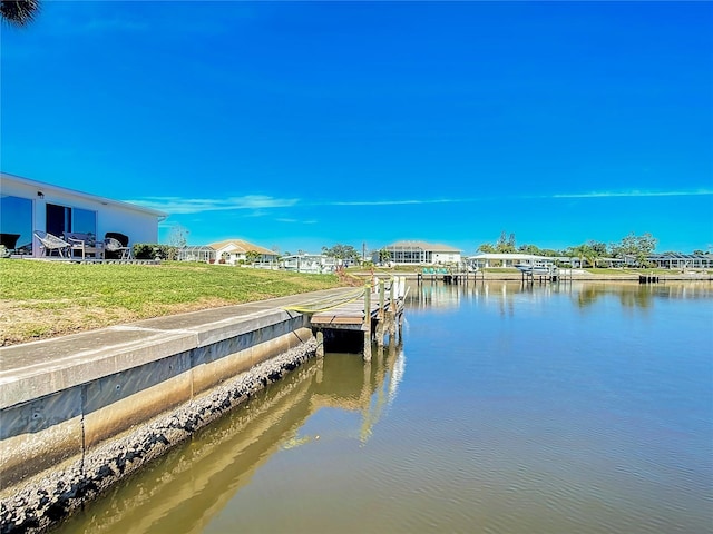 dock area with a water view and a lawn