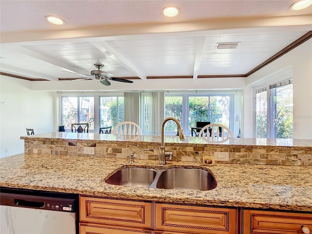 kitchen featuring stainless steel dishwasher, sink, beamed ceiling, and light stone countertops