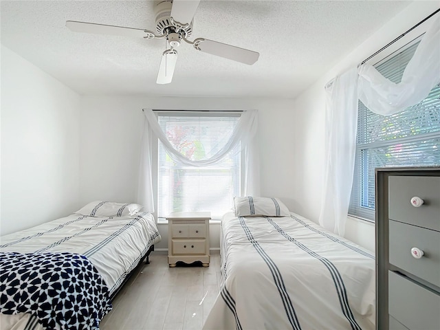 bedroom featuring a textured ceiling, ceiling fan, and hardwood / wood-style flooring