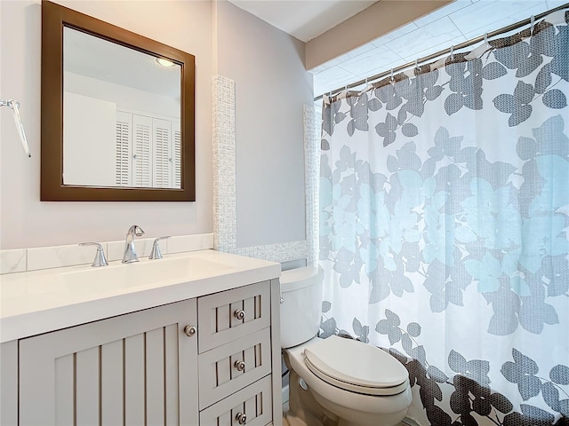 bathroom featuring walk in shower, vanity, and toilet