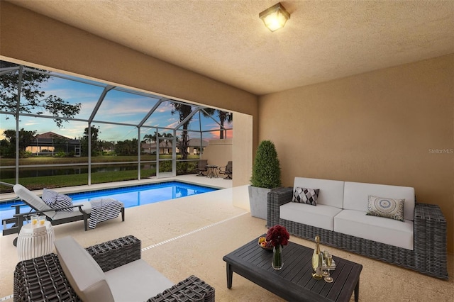 outdoor pool with glass enclosure, a patio area, and an outdoor hangout area