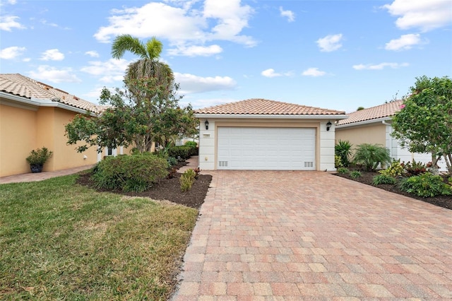 view of front facade with stucco siding, a tile roof, an attached garage, decorative driveway, and a front yard