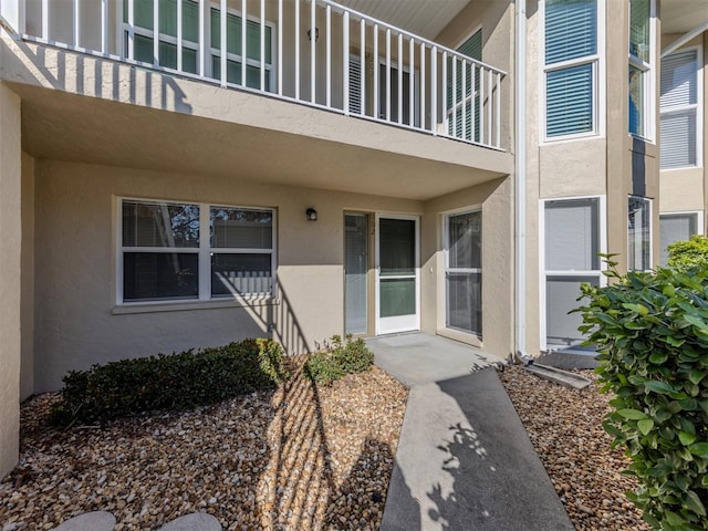 view of exterior entry with a balcony