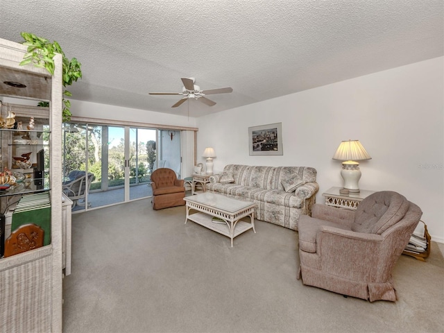 living room with ceiling fan, carpet floors, and a textured ceiling