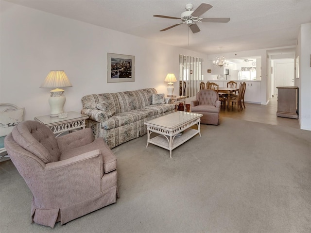 living room with ceiling fan with notable chandelier and carpet