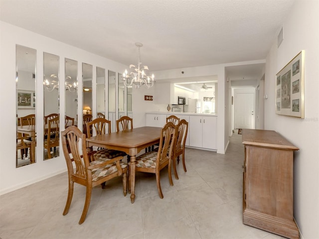 dining space with a notable chandelier, light tile patterned floors, and a textured ceiling