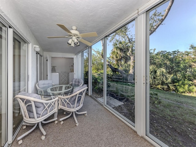 sunroom / solarium featuring washing machine and dryer and ceiling fan