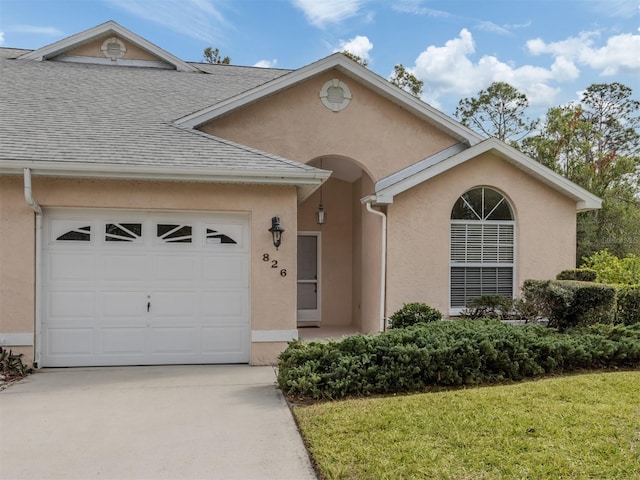 view of front of house featuring a garage and a front lawn