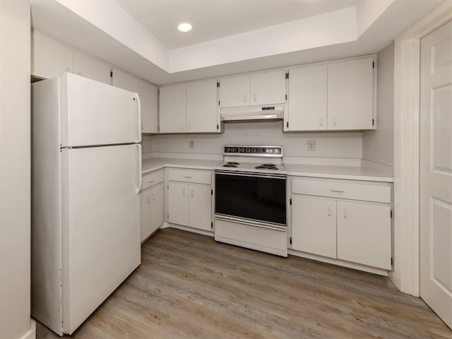 kitchen with white appliances, white cabinets, and a raised ceiling