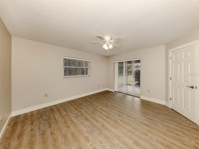 spare room featuring light wood-type flooring, ceiling fan, and a textured ceiling