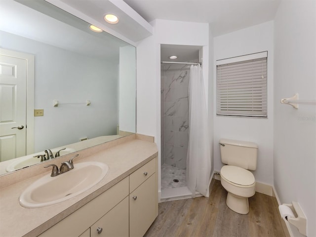 bathroom with wood-type flooring, toilet, vanity, and a shower with curtain