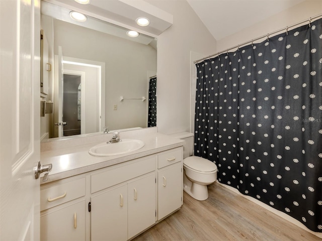 bathroom featuring hardwood / wood-style flooring, toilet, vanity, lofted ceiling, and a shower with shower curtain