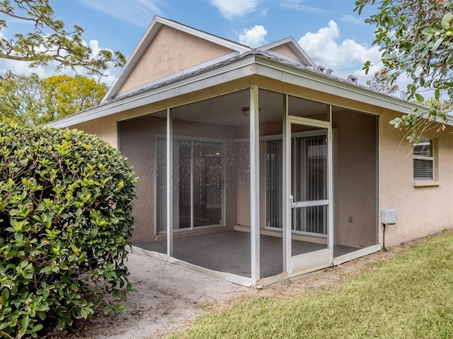 rear view of house with a sunroom and a lawn