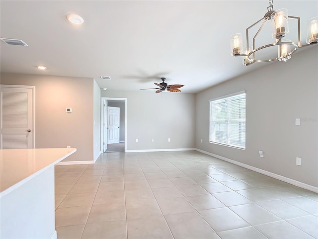 unfurnished living room featuring ceiling fan with notable chandelier and light tile patterned floors