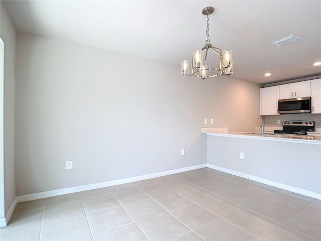 kitchen featuring hanging light fixtures, light tile patterned floors, an inviting chandelier, white cabinetry, and appliances with stainless steel finishes