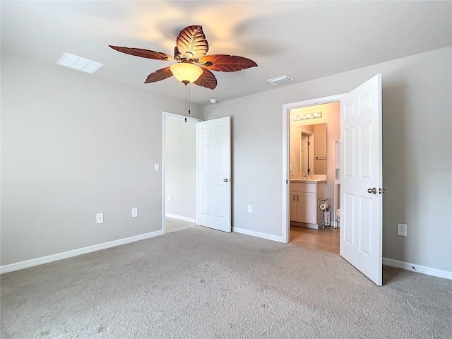 unfurnished bedroom featuring sink, connected bathroom, ceiling fan, and light colored carpet