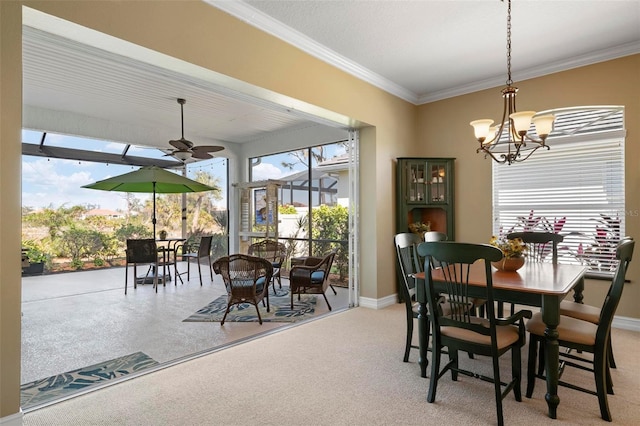 carpeted dining room with ornamental molding and ceiling fan with notable chandelier