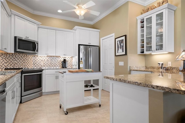 kitchen featuring tasteful backsplash, ornamental molding, stainless steel appliances, and white cabinets