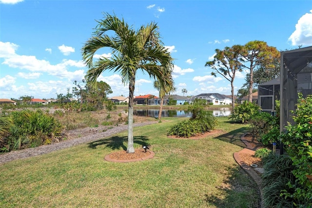 view of yard with a water view and glass enclosure