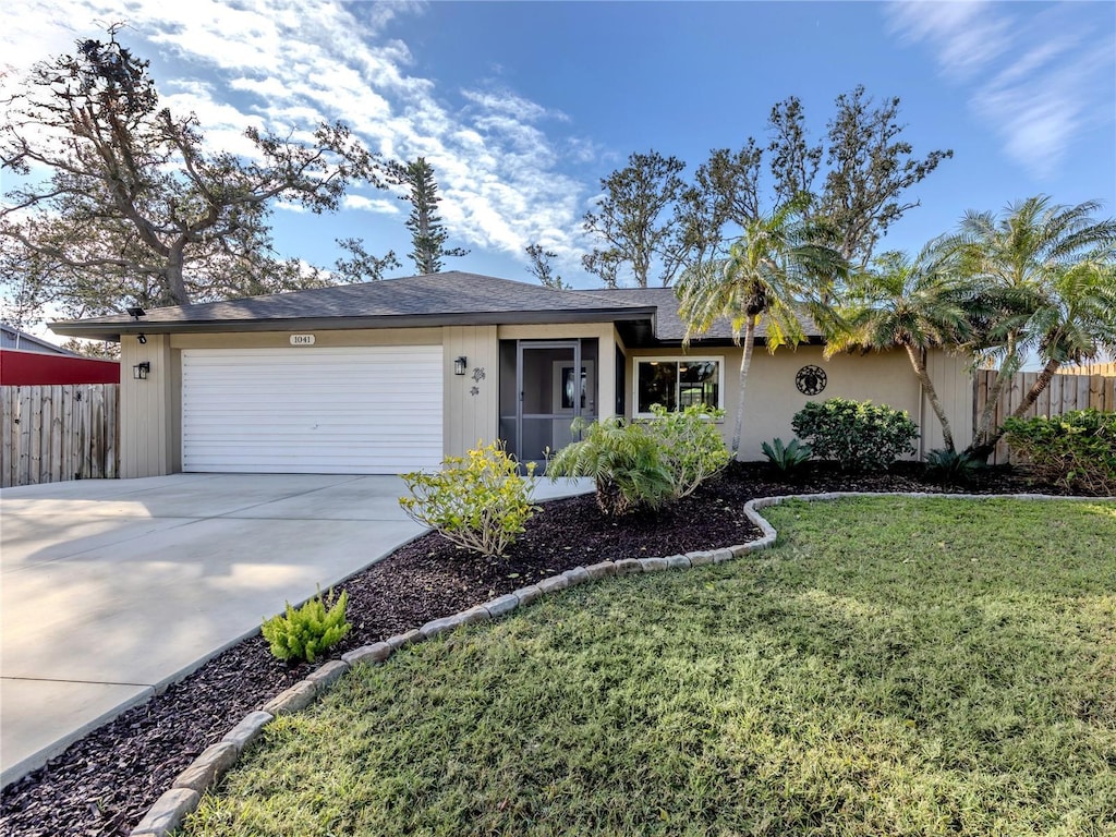 ranch-style home featuring a garage and a front yard