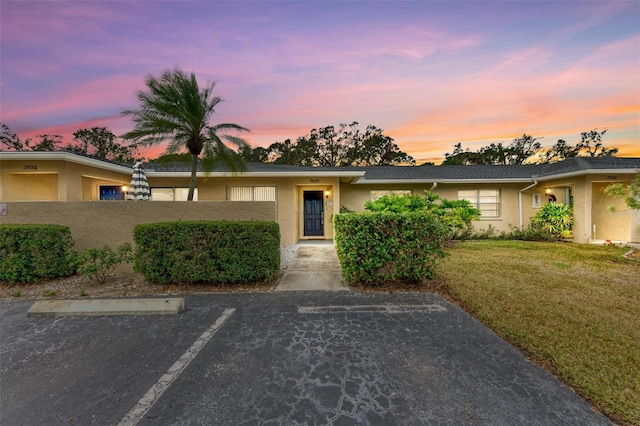 single story home featuring a lawn