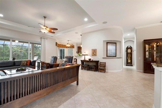 living room featuring ceiling fan, a raised ceiling, ornamental molding, and light tile patterned flooring