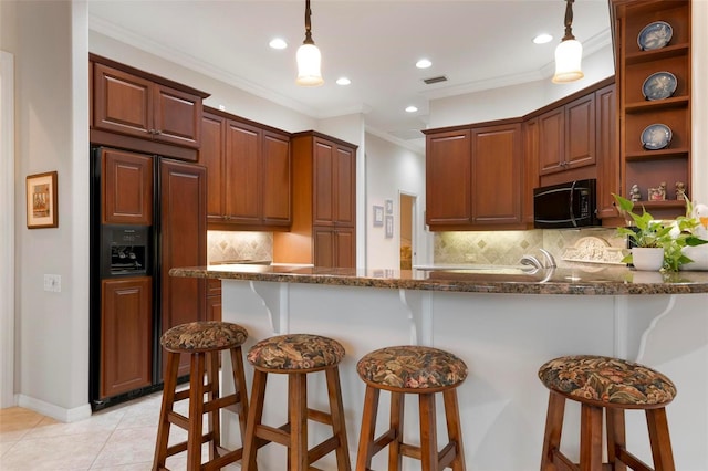 kitchen featuring crown molding, pendant lighting, paneled refrigerator, dark stone countertops, and decorative backsplash