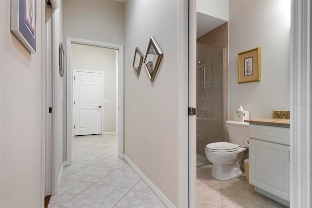 bathroom with vanity, toilet, tiled shower, and tile patterned floors