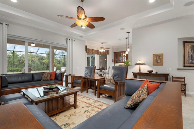 tiled living room featuring ceiling fan, a tray ceiling, and ornamental molding