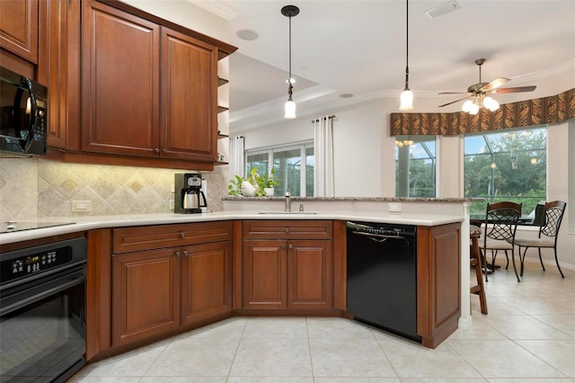 kitchen featuring kitchen peninsula, pendant lighting, tasteful backsplash, a tray ceiling, and black appliances